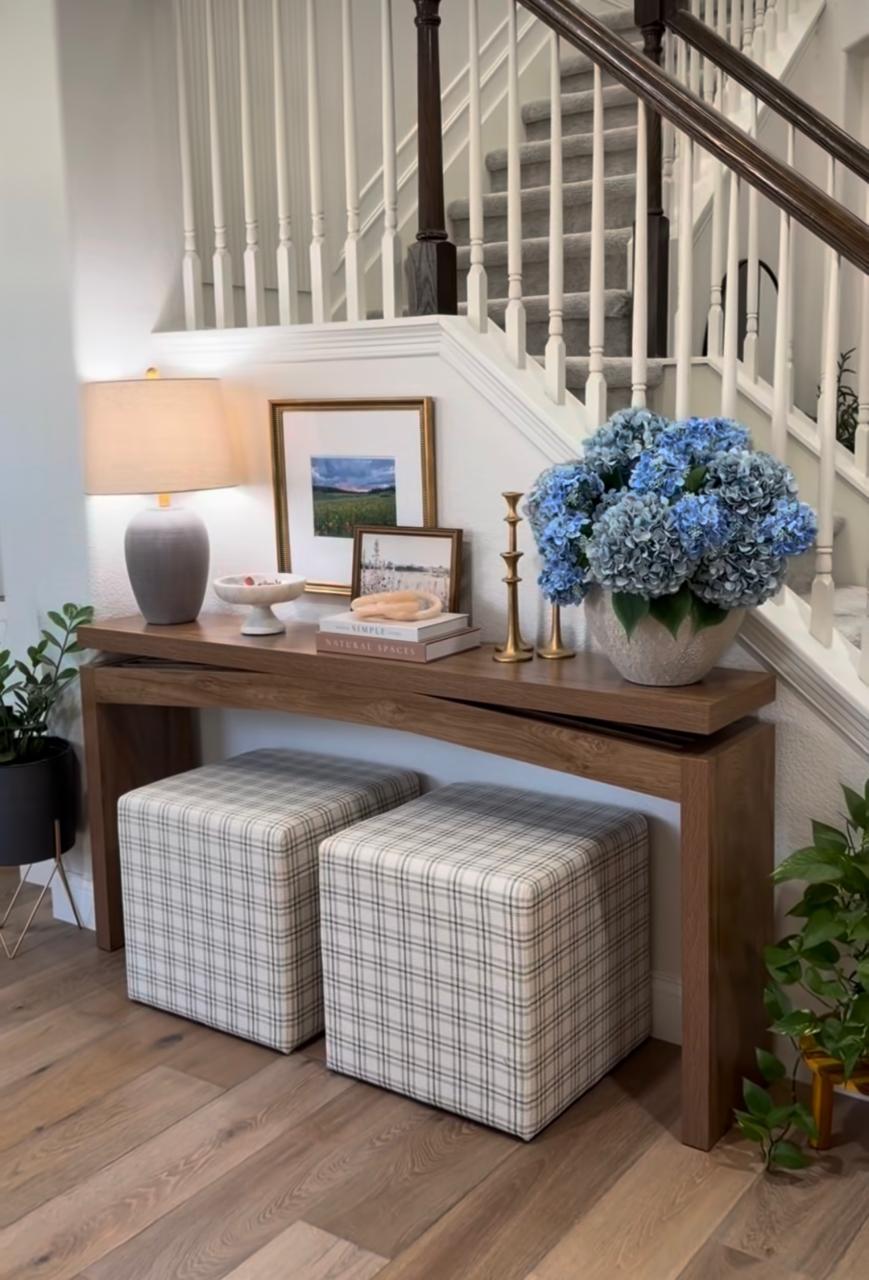 Warm entryway console with lamp, hydrangeas and plaid ottomans